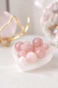 Mini esferas de cuarzo rosa pulidas en una bandeja con forma de corazón